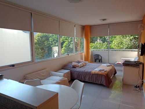 Cet appartement comprend une chambre avec un lit et un salon avec des fenêtres. dans l'établissement SOLAR DEL ABASTO, à Buenos Aires
