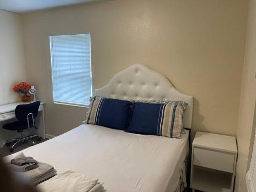 皮爾斯堡的住宿－2 Bedroom House, Ideal for a Family，一间卧室配有一张带蓝色枕头的床和一扇窗户。