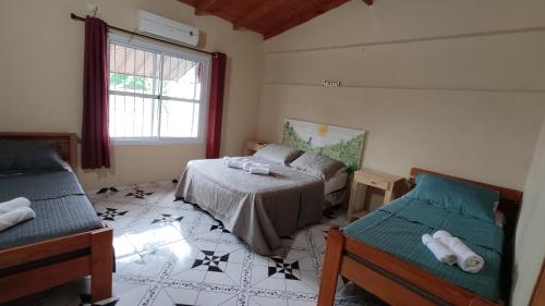 1 dormitorio con 2 camas y ventana en Apart clemencia en Puerto Iguazú