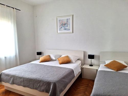 a bedroom with two beds and a window at Apartments by the sea Nevidjane, Pasman - 323 in Neviđane