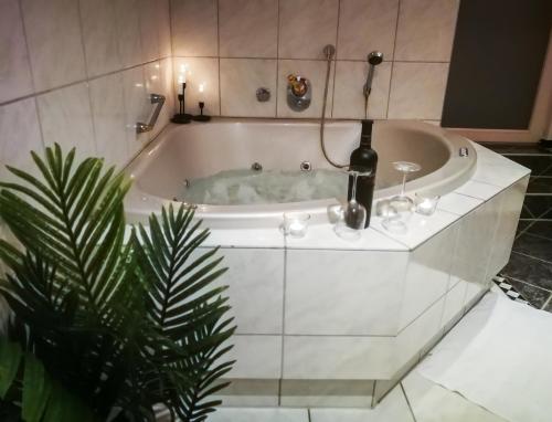 a bath tub with a candle and a plant at Stadtoase Fulda mit flair - Whirlpool, Balkon, 2xParkplätze, Highspeed WLAN in Fulda