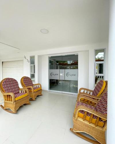 a store with three wicker chairs in front of a store at Hotel Olam Deluxe Valledupar in Valledupar