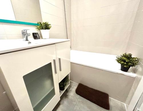 a bathroom with a sink and a tub and a television at Plaza Circular Más que apartamentos in Murcia