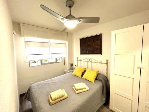 a bedroom with a bed with two yellow pillows at Plaza Circular Más que apartamentos in Murcia