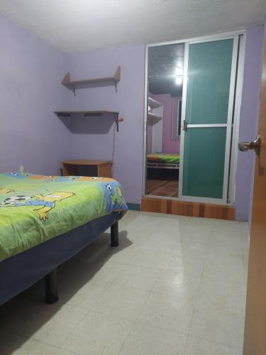 um quarto com uma cama e uma porta de vidro deslizante em Habitación privada en Casa compartida, 4 adultos em Cidade do México