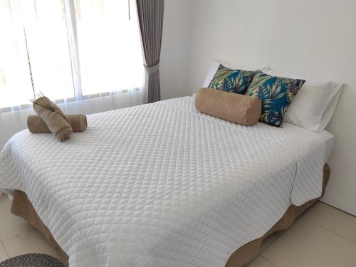 a white bed with two pillows on top of it at Apt Morpho Cas'Aguacate close to Airport, Pedregal, Centro Convenciones in Potrerillos