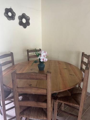 a dining room table with a vase of flowers on it at Villa Familiar con Piscina Privada y Rio in Bonao