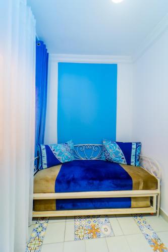a bedroom with a bed with a blue head board at Dar Jinane in Chefchaouene