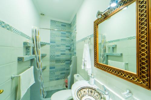 a bathroom with a mirror and a toilet at Dar Jinane in Chefchaouene