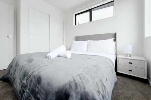 a bedroom with a large bed with white pillows at Modern 3-bds townhouse in South Auckland in Auckland