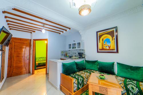 a living room with a green couch and a table at Dar Jinane in Chefchaouene