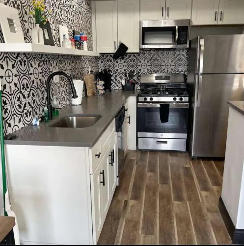 a kitchen with a sink and a stainless steel refrigerator at Studio W&D Parking Mins to STL Zoo Forest Park in Tower Grove