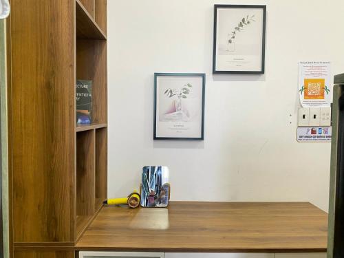 a desk with three framed pictures on a wall at Start House DORM Walk 5 Minutes to the Airport in Ho Chi Minh City