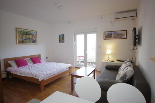 ein Wohnzimmer mit einem Bett und einem Sofa in der Unterkunft Studio Apartment Danijela in Igalo