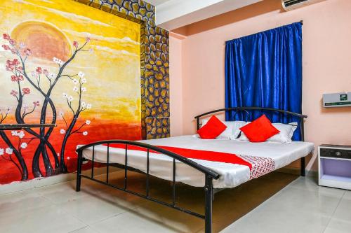 a bedroom with a bed with a painting on the wall at OYO Hotel River View in Patna