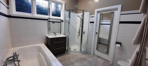 a bathroom with a tub and a sink and a shower at Spacious Comfortable House in Wellington