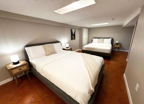1 dormitorio con 2 camas y 2 mesas con lámparas en Entire house with Park parking in large backyard, en Richmond Hill