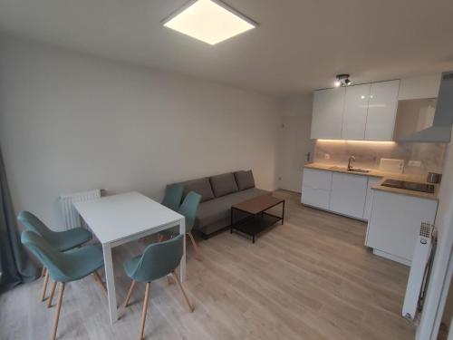 a kitchen and a living room with a table and chairs at Joli Appartement 2 pièces avec un grand jardin in Aubervilliers