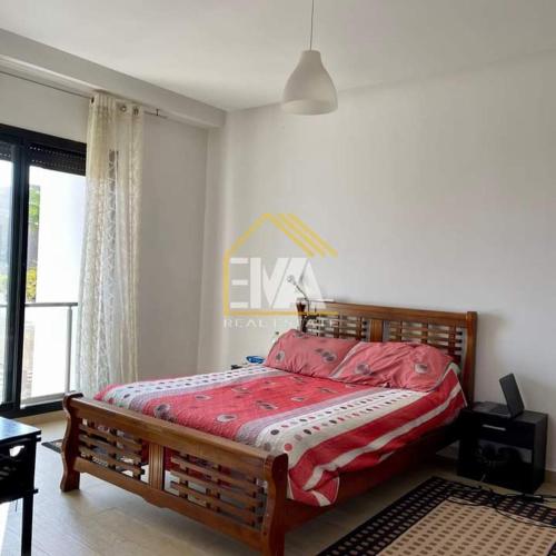 sypialnia z łóżkiem z czerwoną pościelą i oknem w obiekcie Splendide villa prestigia plage des nations w mieście Sidi Bouqnadel