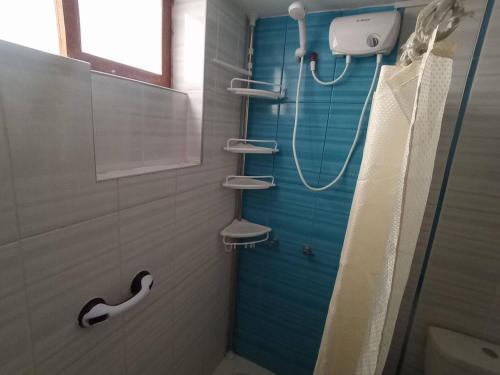 een badkamer met een douche, een toilet en een wastafel bij Siéntete como en casa in Ilo
