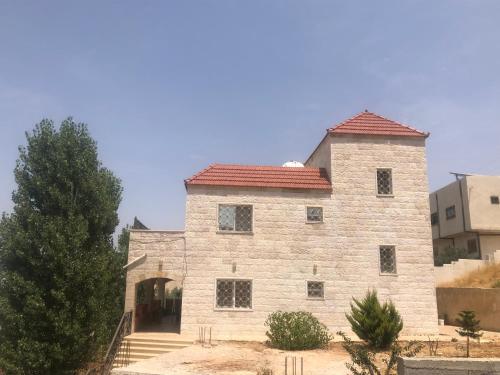 a large stone building with a red roof at عجلون Ajloun in Ajloun