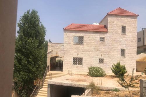 a large stone building with a red roof at عجلون Ajloun in Ajloun