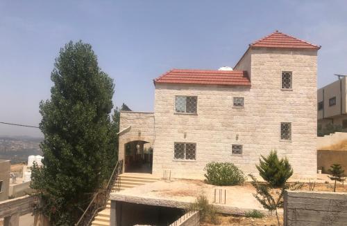 a large stone building with a red roof at عجلون Ajloun in Ajloun