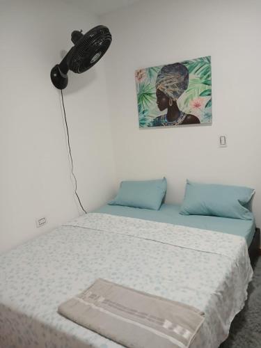 een slaapkamer met een bed en een ventilator aan de muur bij Apto. 2 alcobas, Tercer piso, Norte de Cali in Cali