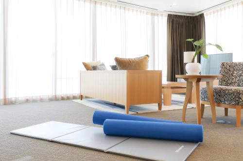 a living room with a couch and a yoga mat at 3 Wellness in Okayama