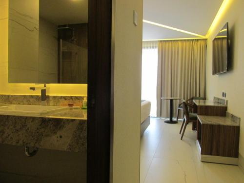 a bathroom with a sink and a desk in a room at Hotel Antré Chapultepec in Guadalajara