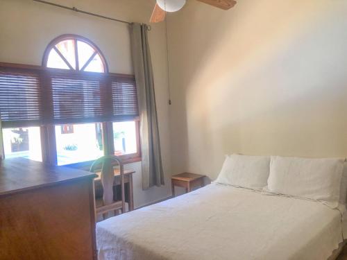 een slaapkamer met een wit bed en een raam bij Bel Air/Sutton in San Juan del Sur