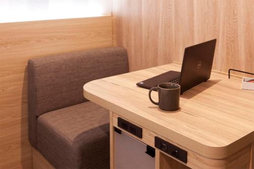 a laptop computer sitting on a desk with a chair at Kumamoto Washington Hotel Plaza in Kumamoto