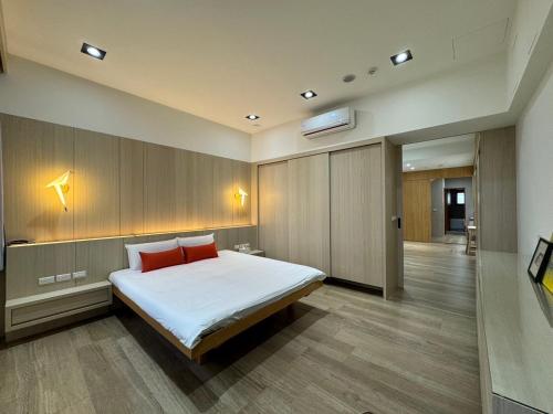 ein Schlafzimmer mit einem großen Bett mit zwei roten Kissen in der Unterkunft Triple One Entire Home 慶東111私人招待所 包棟民宿 in Tainan