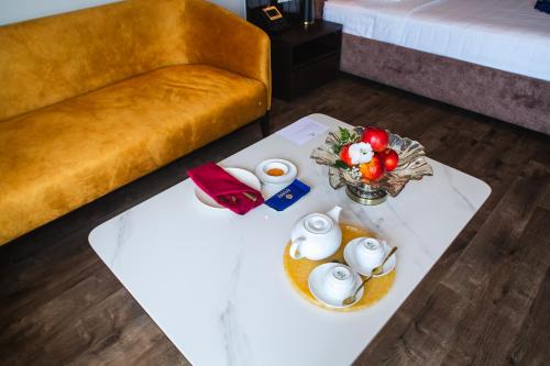 a room with a table with eggs and a couch at SANDALS AQUILA HOTEL in Bao Loc