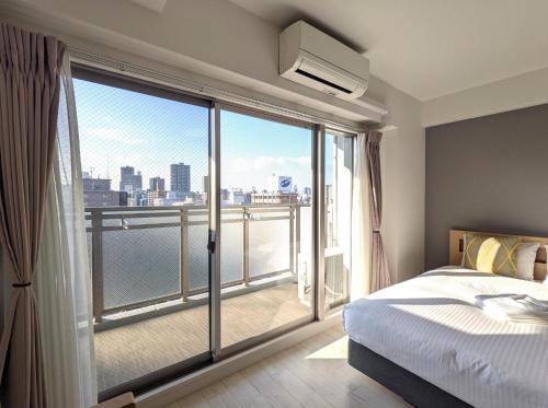 a bedroom with a bed and a large window at Eslead Hotel Osaka Tsuruhashi - Vacation STAY 77737v in Osaka