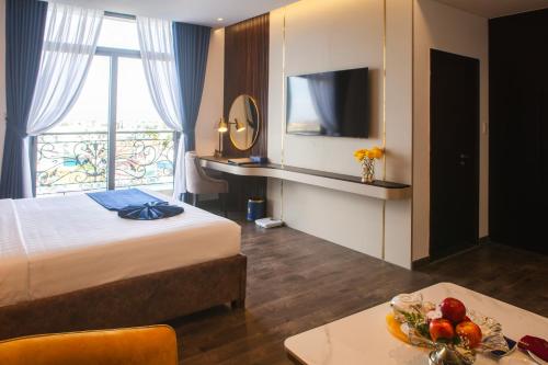 a hotel room with a bed and a table with a bowl of fruit at SANDALS AQUILA HOTEL in Bao Loc