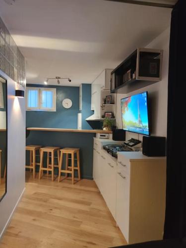 - une cuisine avec un comptoir et une télévision dans l'établissement Le nid douillet - Cosy and very close to Paris, à Asnières-sur-Seine