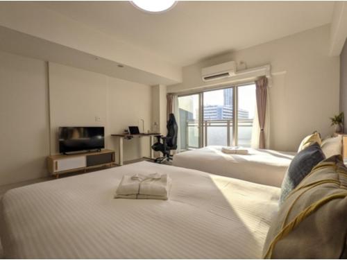 a hotel room with two beds and a television at Eslead Hotel Osaka Tsuruhashi - Vacation STAY 77569v in Osaka
