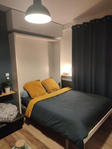 une chambre avec un lit avec des oreillers jaunes dans l'établissement Le nid douillet - Cosy and very close to Paris, à Asnières-sur-Seine