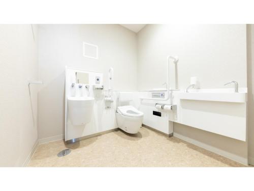 a white bathroom with a toilet and a sink at Eslead Hotel Osaka Tsuruhashi - Vacation STAY 77560v in Osaka
