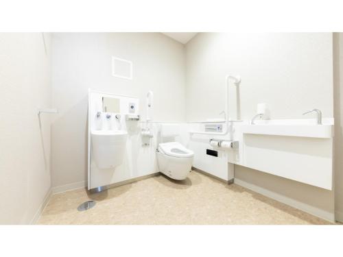 a white bathroom with a toilet and a sink at Eslead Hotel Osaka Tsuruhashi - Vacation STAY 77569v in Osaka
