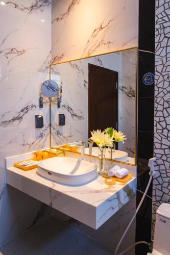 a bathroom with a sink and a mirror at SANDALS AQUILA HOTEL in Bao Loc