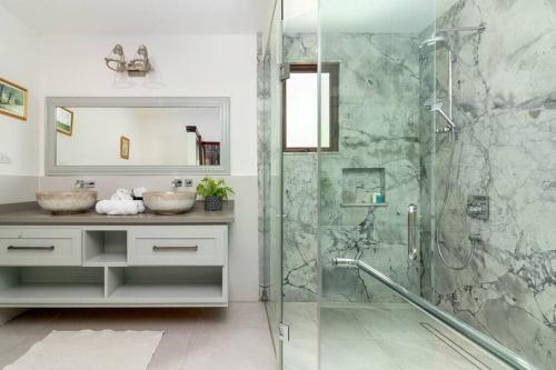 W łazience znajduje się szklana kabina prysznicowa i umywalka. w obiekcie Oceanfront Luxe Villa In St Mary Fully Staffed w mieście Saint Mary