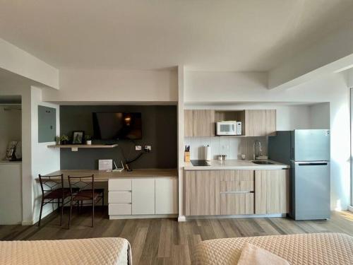 Jemet - Moderno Apartamento Doble في غواتيمالا: مطبخ صغير مع طاولة وثلاجة