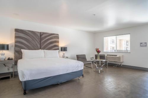 a bedroom with a large bed and a table at Aqua Soleil Hotel and Mineral Water Spa in Desert Hot Springs