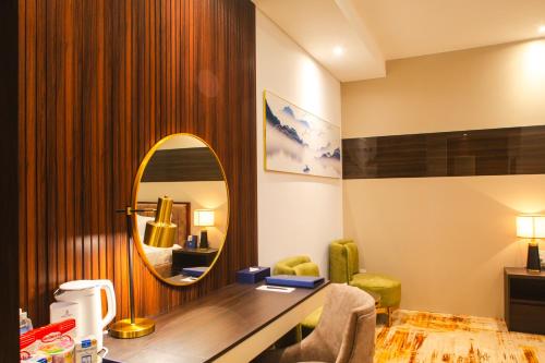 a hotel room with a desk and a mirror at SANDALS AQUILA HOTEL in Bao Loc