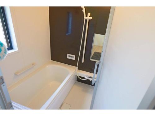 ein Badezimmer mit einer Badewanne und einem Waschbecken in der Unterkunft Ciao No,361 - Vacation STAY 61635v in Tsukuba