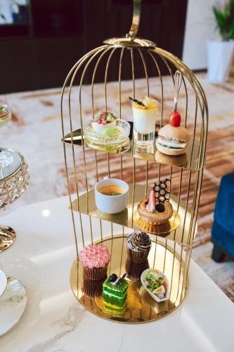 a cage filled with cupcakes and desserts on a table at SANDALS AQUILA HOTEL in Bao Loc