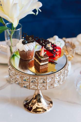 a plate of cakes and cupcakes on a table at SANDALS AQUILA HOTEL in Bao Loc