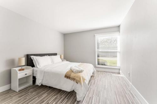Habitación blanca con cama y ventana en Cozy 2 Bedroom Stay in Rochester Hills, en Rochester Hills